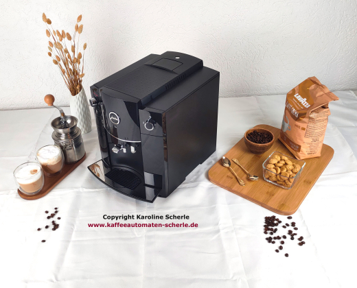 JURA D60 Schwarz / Piano Black schräg von rechts mit dunkler Seitenwand, Kaffeeauslauf und Tassenplattform