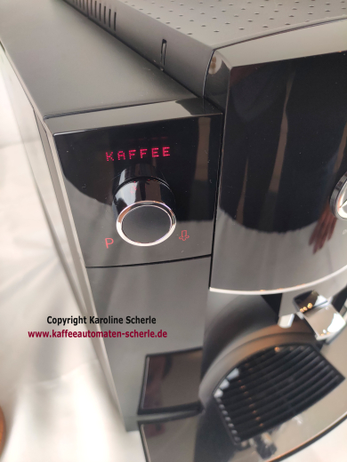 Nahaufnahme der JURA D60: rotes Klartextdisplay mit Anzeige Kaffee über dem Rotary Switch