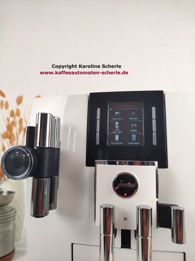 Detail der JURA J6 mit TFT-Farbdisplay, Hinweis Milchsystem spülen und Einstellrad an der Cappuccino-Düse