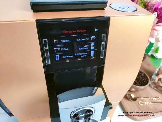 Nahaufnahme des TFT-Farbdisplays mit Getränketasten und angrenzender gold folierter Front der JURA Z6